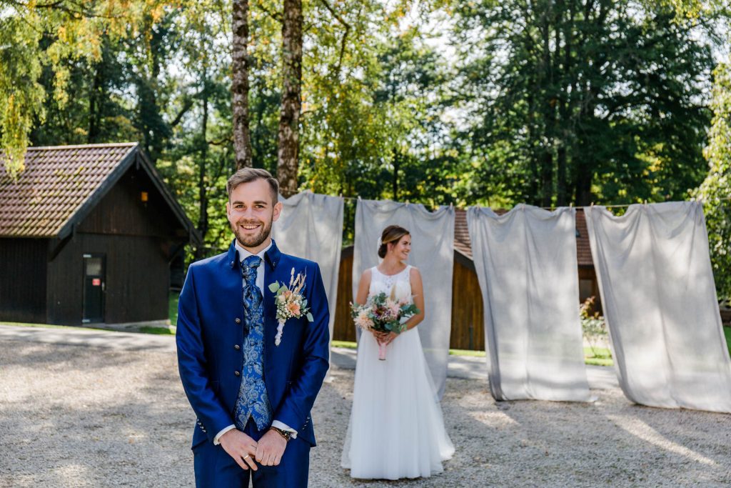 Hochzeitsfotografin Christina Klass, Authentische Bräutigamfotografie, Braut im Hintergrund