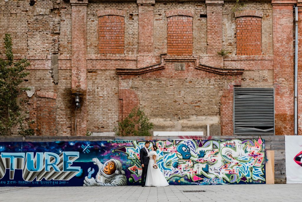 Brautpaar an einer Graffiti-Wand, Hochzeitsfotografin Christina Klass