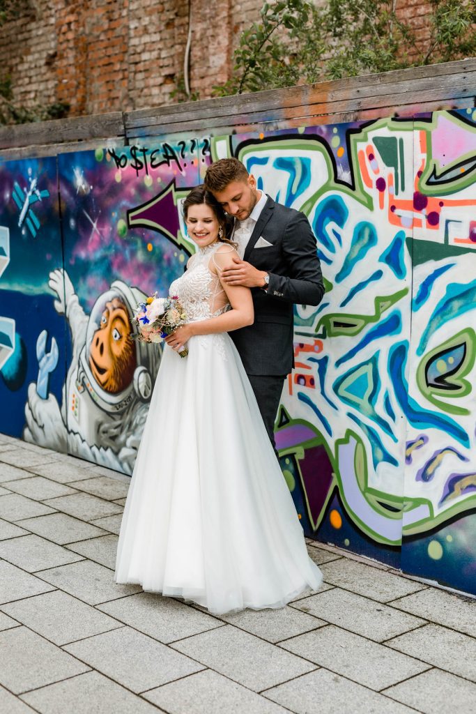 Brautpaar an einer Graffiti-Wand, Hochzeitsfotografin Christina Klass