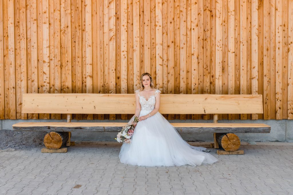 Hochzeitsfotografie Landsberg, Braut auf einer Holzbank, fotografiert von Hochzeitsfotografin Augsburg Christina Klass, Brautpaarshooting in Augsburg, Braut Portrait