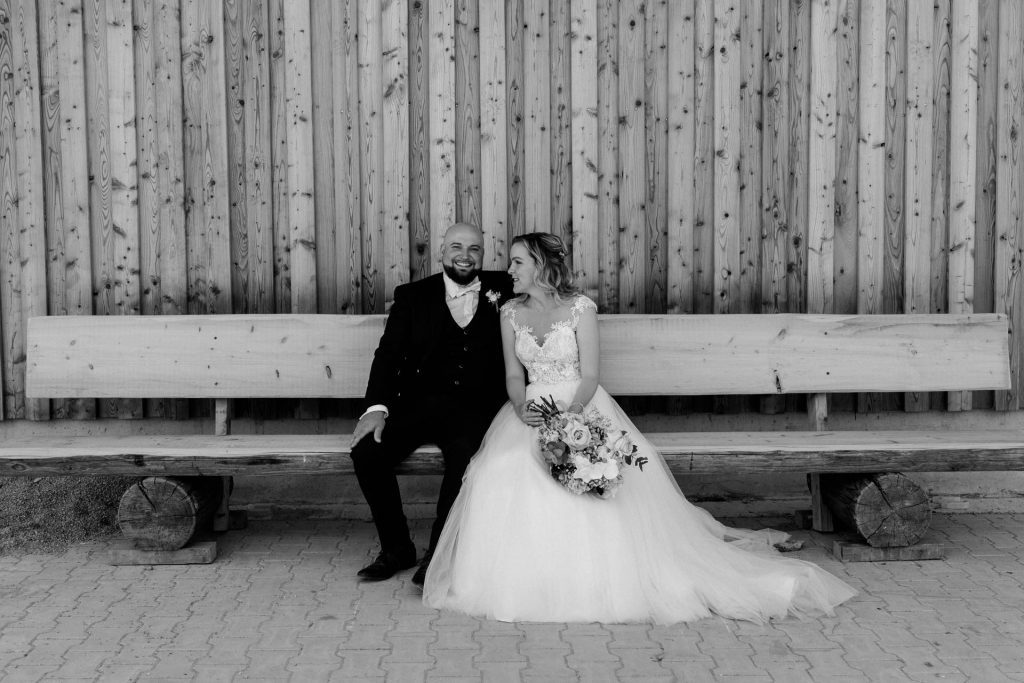 Hochzeitsfotografin Christina Klass, Brautpaar auf einer Holzbank