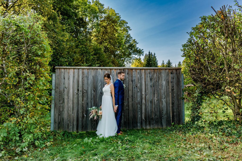 Hochzeitfotografin Christina Klass, Romantische Brautpaarfotos vor einem Holztor